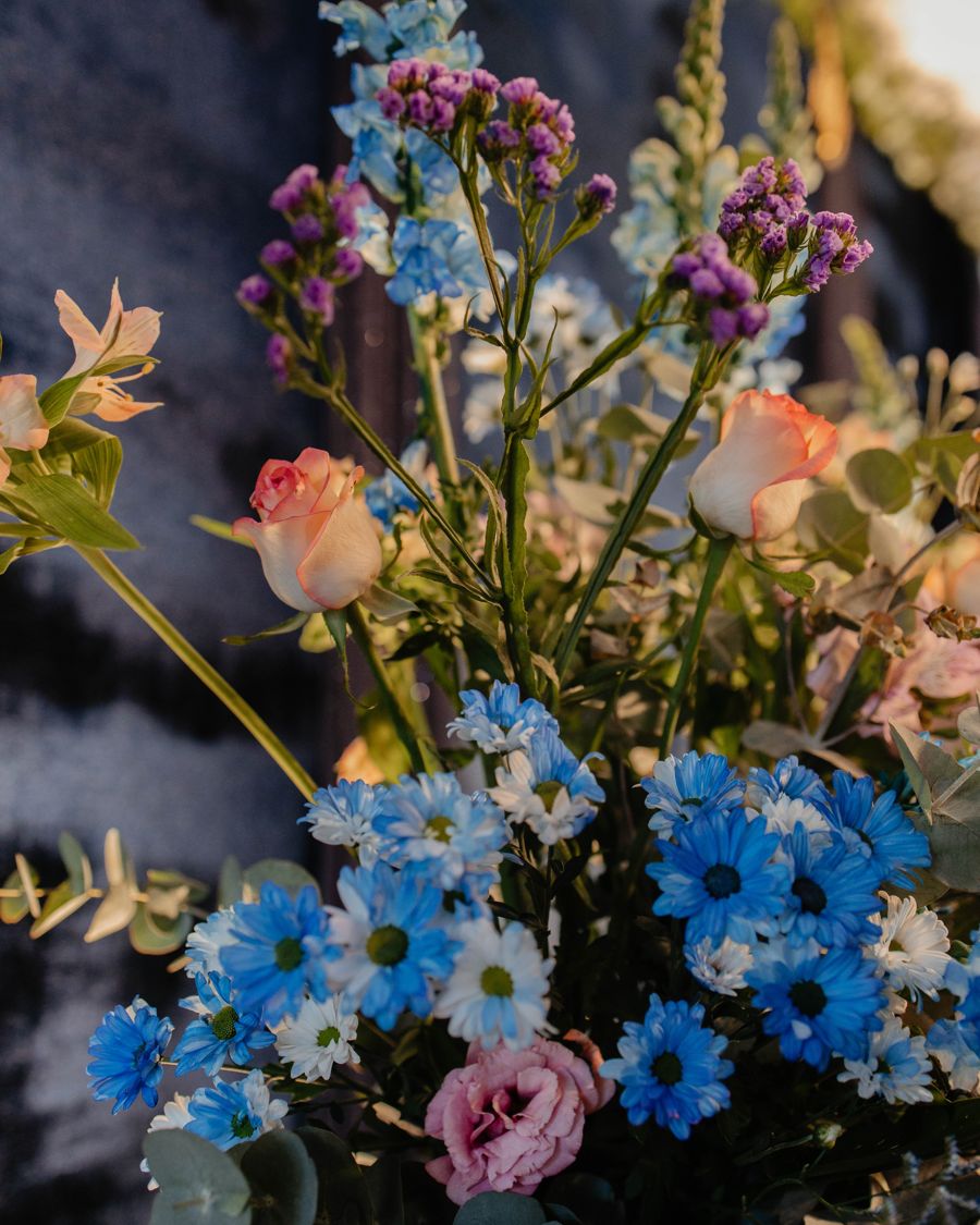Flores azuis e lilás em volta da mesa.