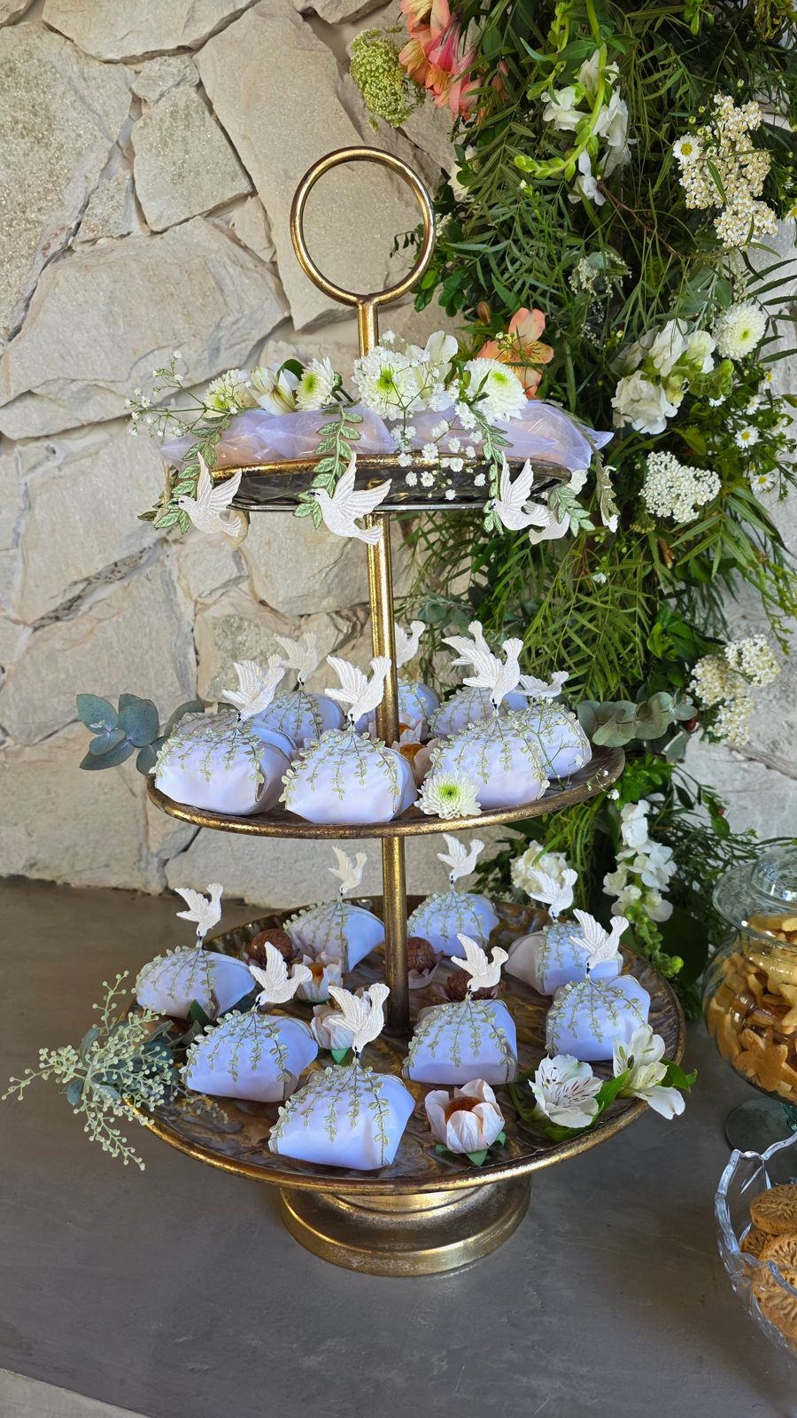 Doces azuis entre pombas brancas, numa torre de bandejas.