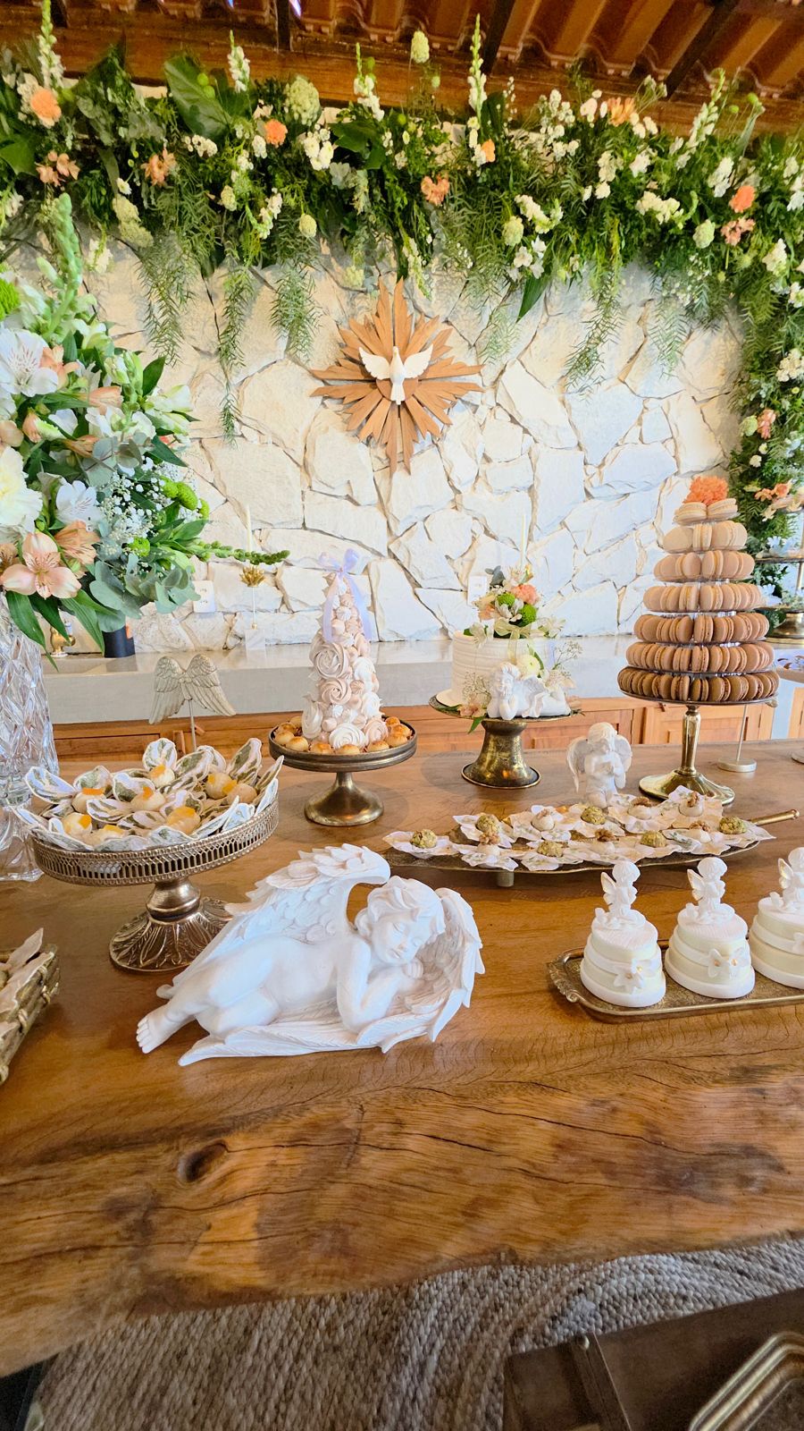 A mesa principal, com o anjo, a torre de macarons e a pomba ao fundo.