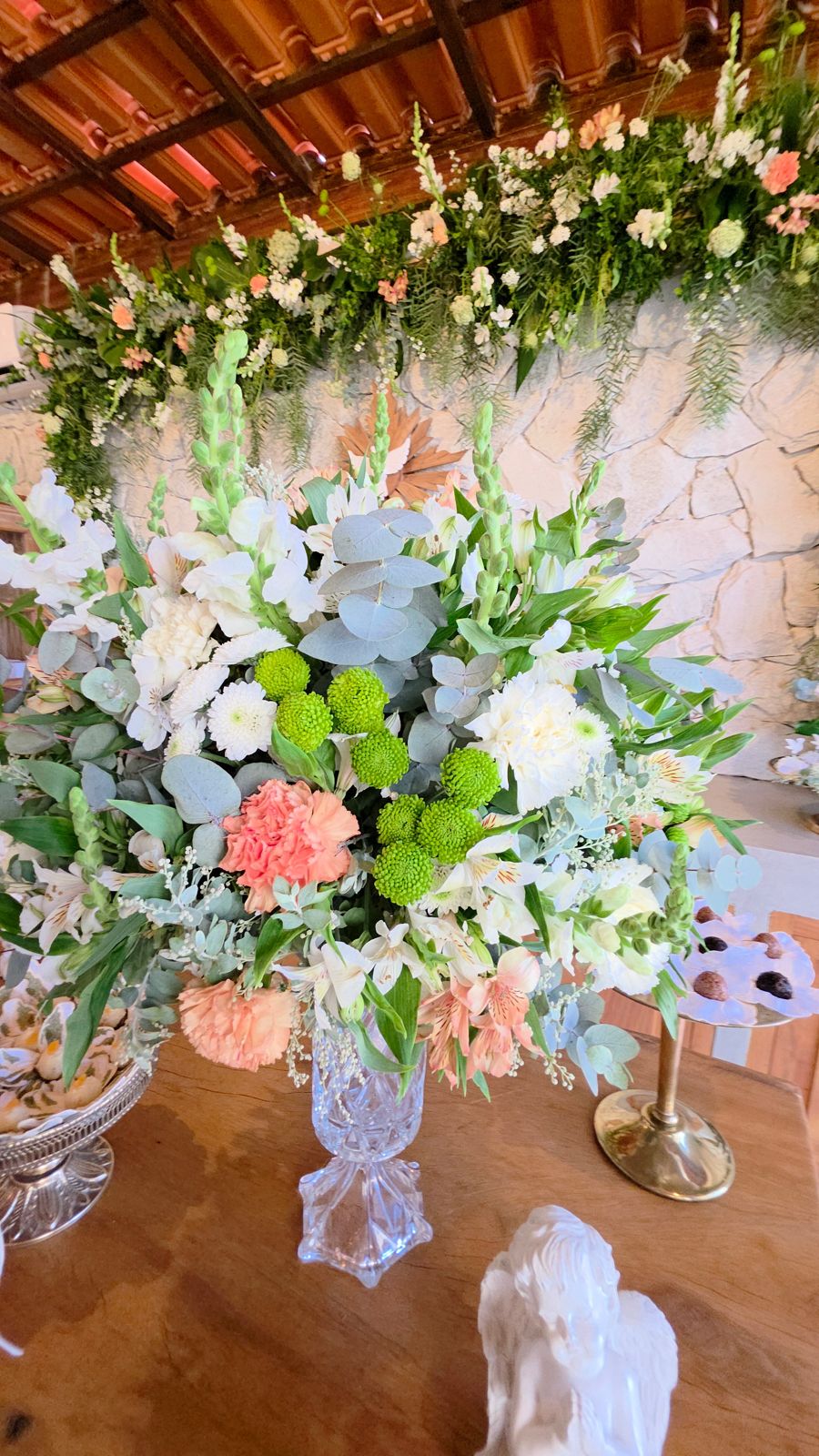 Um grande arranjo de flores diante da parede de pedra.