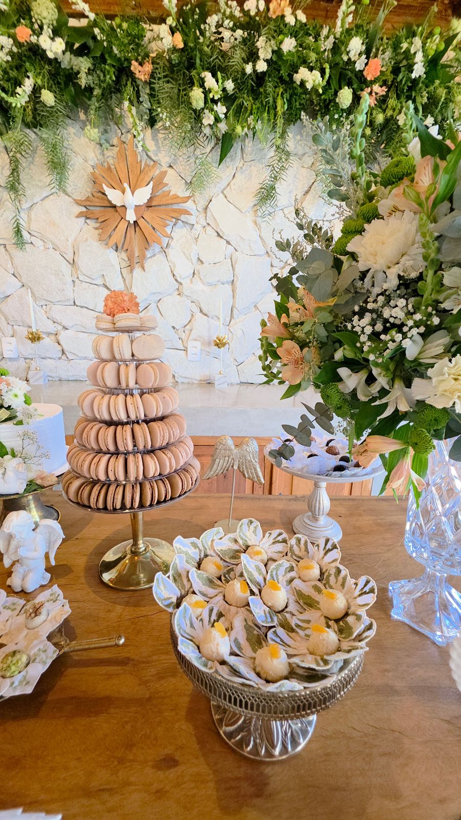 A mesa com a torre de macarons e os docinhos em forma de flor.