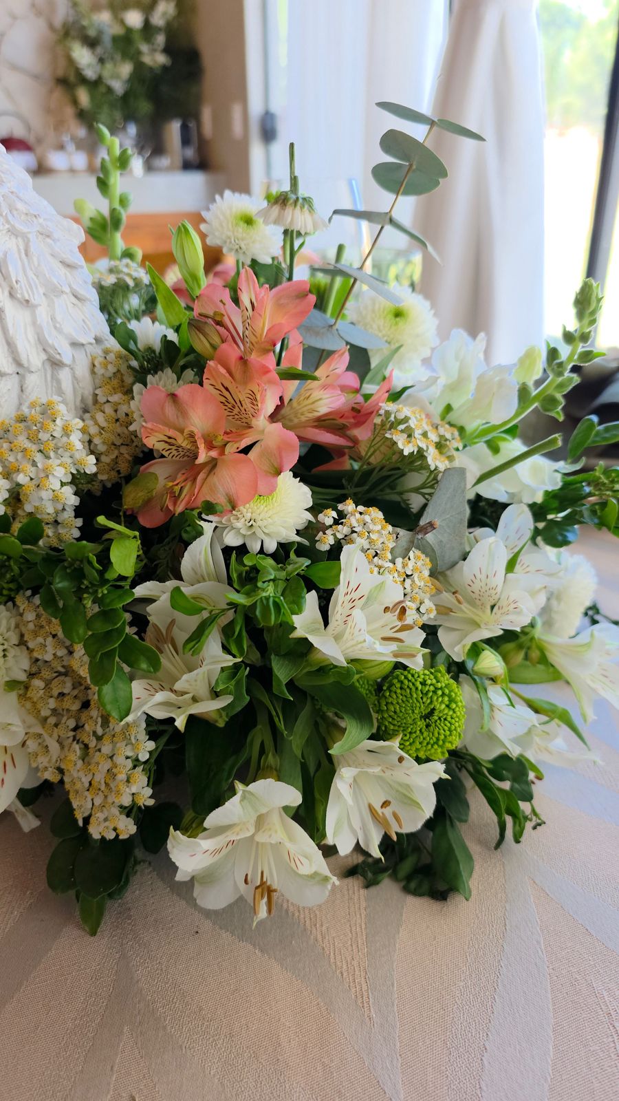 Um arranjo de flores sobre a mesa dos doces.