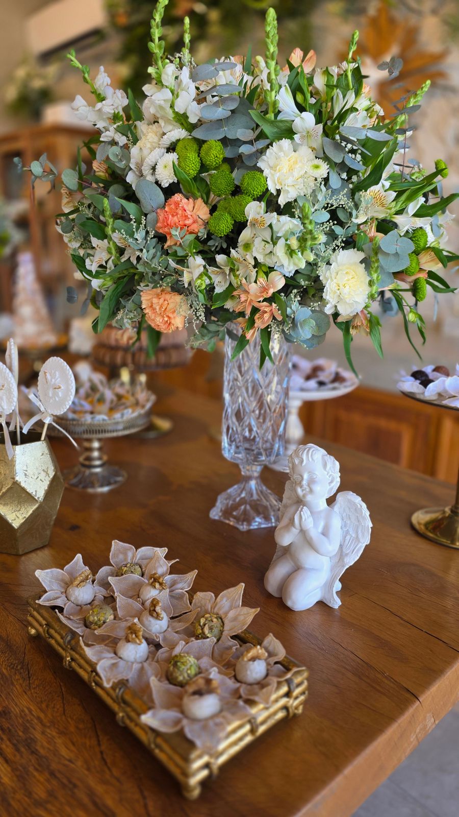 Flores brancas e salmão em vaso de cristal.