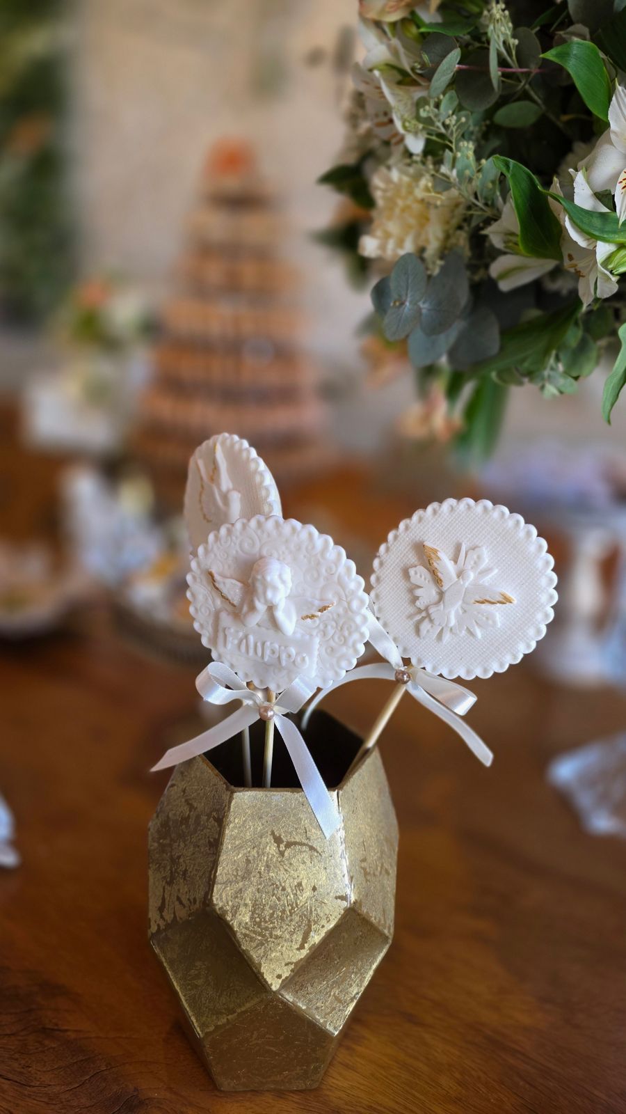 Pirulitos de biscuito com anjinhos, em vaso dourado.