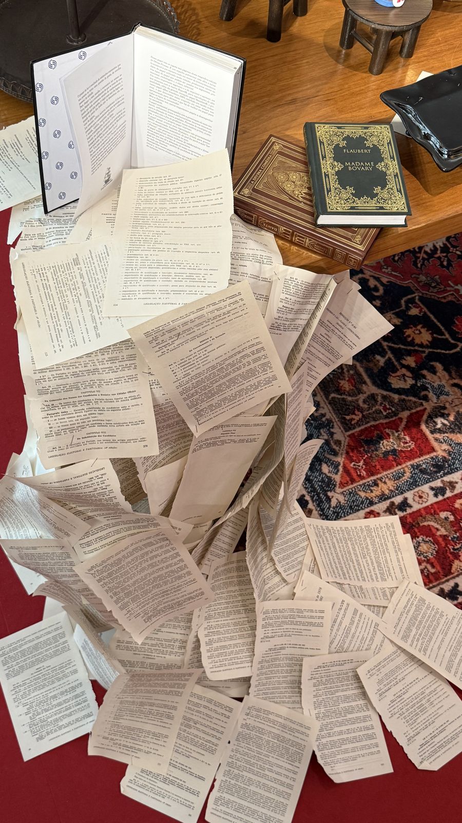 Páginas de livro caindo em cascata sobre o tapete.