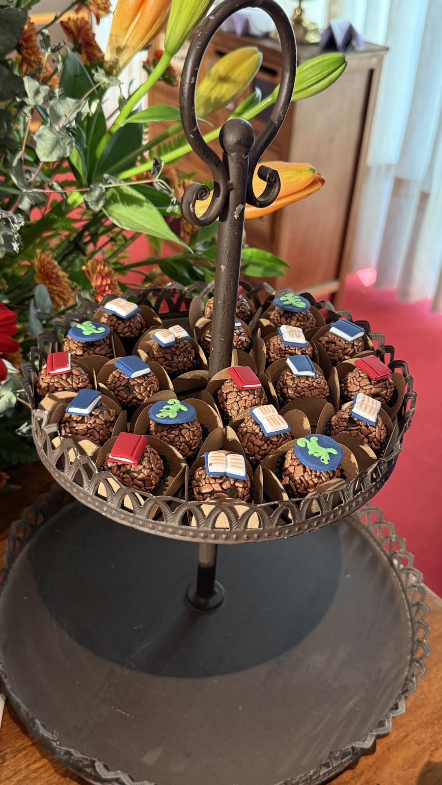 Brigadeiros com livrinhos e um lagarto de açúcar.