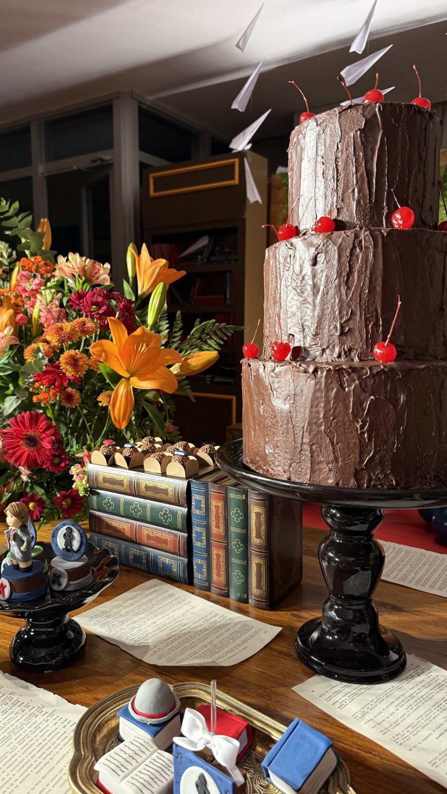 O bolo de chocolate de três andares, com cerejas.